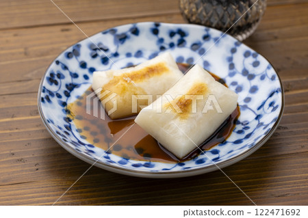 Grilled rice cakes and sugar soy sauce served on a blue Japanese patterned plate Grilled rice cakes and sugar soy sauce served on a blue Japanese patterned plate 122471692