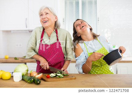 Senior woman and her daughter cooking dinner together 122471708
