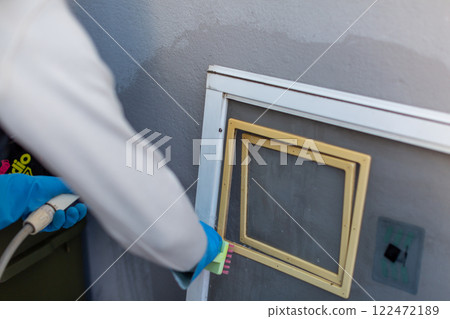 Man washing screen door DIY spring cleaning 122472189