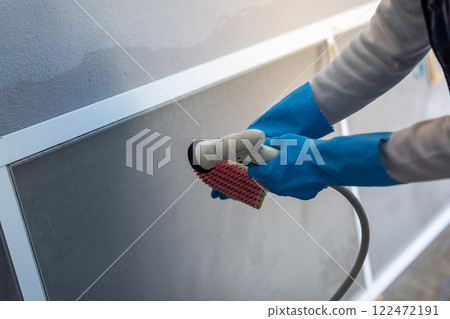 Man washing screen door DIY spring cleaning 122472191