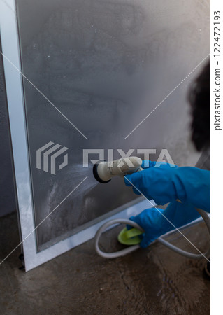 Man washing screen door DIY spring cleaning 122472193