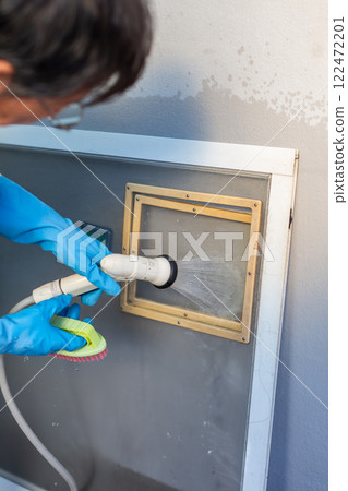 Man washing screen door DIY spring cleaning Man washing screen door DIY spring cleaning 122472201