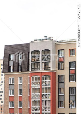 Contemporary apartment building with varied facade styles and balconies, featuring neutral and bold colors, under bright sky Contemporary apartment building with varied facade styles and balconies, featuring neutral and bold colors, under bright sky 122472600