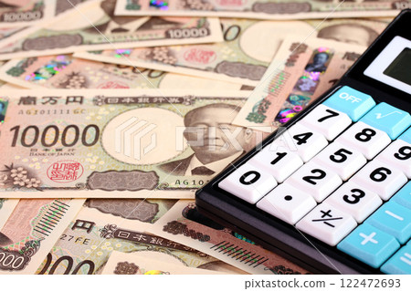 許多 10,000 日元鈔票和一台計算器 122472693