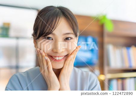 Portrait of a woman in her twenties touching her cheek 122472890