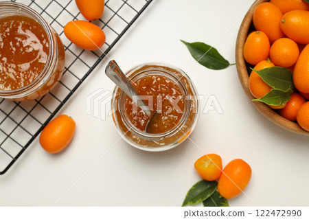 Kumquat in bowl and jars of jam on white background, top view Kumquat in bowl and jars of jam on white background, top view 122472990
