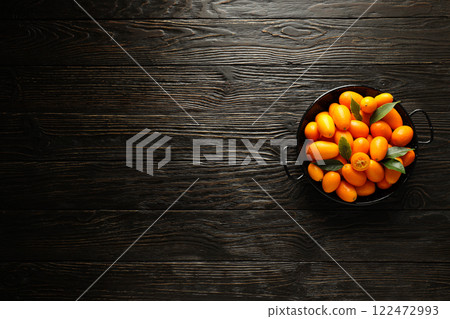 Kumquat in bowl on dark wooden background, space for text Kumquat in bowl on dark wooden background, space for text 122472993