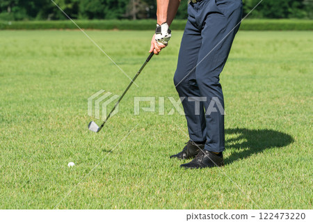 Feet of a male golfer playing golf on a golf course (iron shot) Feet of a male golfer playing golf on a golf course (iron shot) 122473220