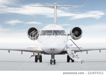 Front view of the luxury corporate aircraft with an opened gangway isolated on bright background with sky Front view of the luxury corporate aircraft with an opened gangway isolated on bright background with sky 122473311