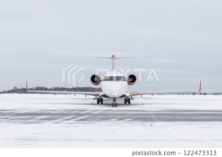 Front view of a passenger regional jet taxiing at winter airport 122473313