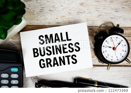 Small Business Grants text with alarm clock and calculator on wooden background, Business concept Small Business Grants text with alarm clock and calculator on wooden background, Business concept 122473369