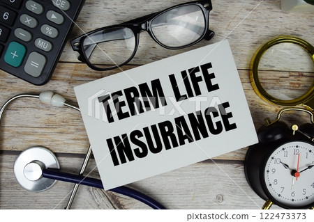 Term Life Insurance text with calculator, magnifying glass and alarm clock on wooden background 122473373