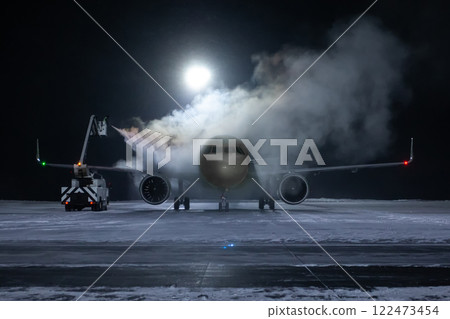 Ground deicing of a passenger aircraft on the night airport apron at winter Ground deicing of a passenger aircraft on the night airport apron at winter 122473454