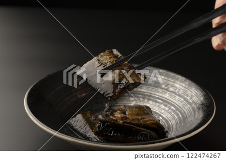 Picking up sweet-simmered herring with chopsticks 122474267