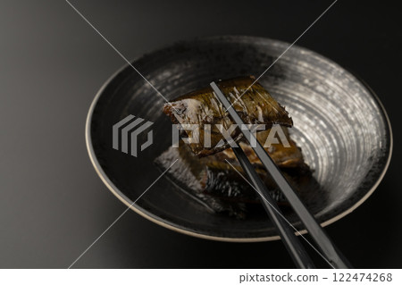 用筷子夾起甜燉鯡魚 用筷子夾起甜燉鯡魚 122474268