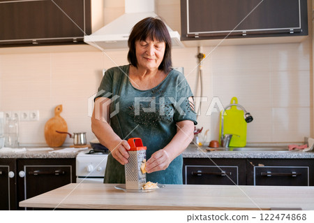 Woman is in a kitchen, preparing food 122474868