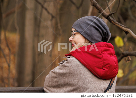 Enjoying a serene moment in nature while wrapped in a cozy jacket during autumns embrace 122475181