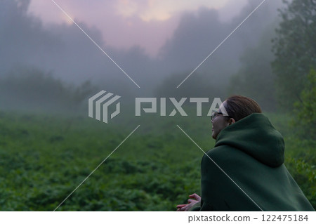 Contemplative moment in a foggy landscape at dawn with soft light illuminating the misty surroundings Contemplative moment in a foggy landscape at dawn with soft light illuminating the misty surroundings 122475184
