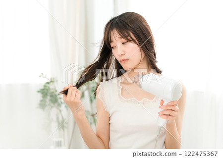 女人用吹風機吹乾頭髮（護髮） 122475367