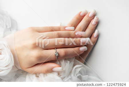 Bride showing her beautiful white nails and engagement ring Bride showing her beautiful white nails and engagement ring 122475924