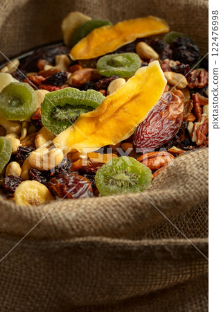 Dried tropical fruits and nuts in burlap bag. Dried tropical fruits and nuts in burlap bag. 122476998