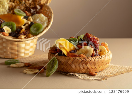 Dried tropical fruits, nuts and raisins on a beige background. Dried tropical fruits, nuts and raisins on a beige background. 122476999