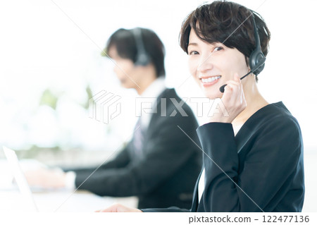 Female staff receiving calls at a call center 122477136