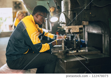 african black male worker working in heavy metal industry factory punching stamping steel machine african black male worker working in heavy metal industry factory punching stamping steel machine 122478073