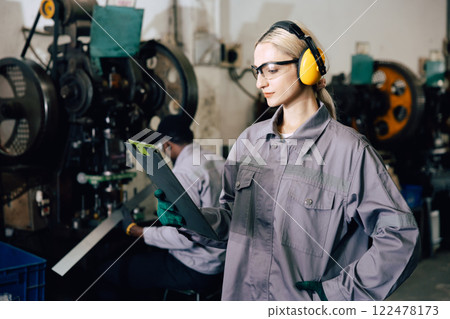 professional engineer caucasian women inspecting auditing old machine in heavy industry factory 122478173