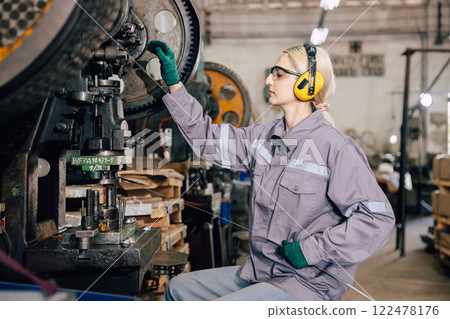 caucasian women worker working in heavy metal industry factory punching stamping steel machine 122478176