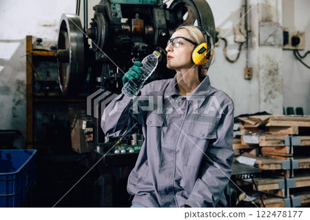 tired fatigue exhausted women worker drinking water brake relax at heavy metal factory tired fatigue exhausted women worker drinking water brake relax at heavy metal factory 122478177