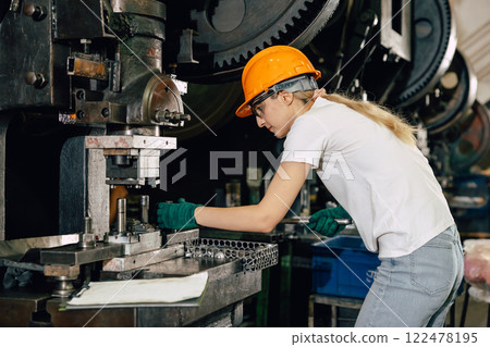 female technician worker working in heavy industry factory fixing service maintenance old machine 122478195
