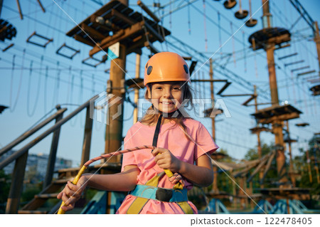 Cheerful little girl child ready to overcome obstacles in rope park Cheerful little girl child ready to overcome obstacles in rope park 122478405