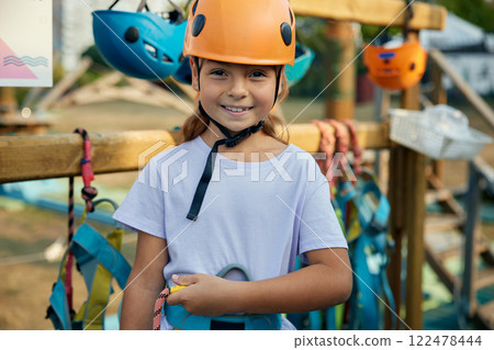 Portrait of brave little girl child wearing helmet at outdoor rope park Portrait of brave little girl child wearing helmet at outdoor rope park 122478444