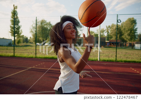 Attractive basketball player spinning ball on finger showing trick 122478467