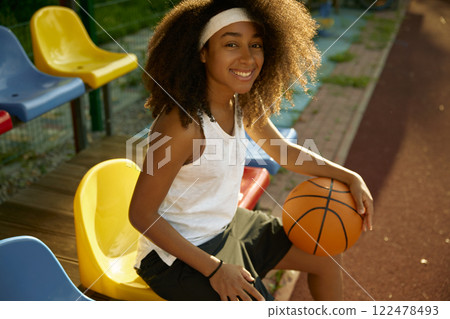 Cute young sportswoman with basketball ball in hands Cute young sportswoman with basketball ball in hands 122478493