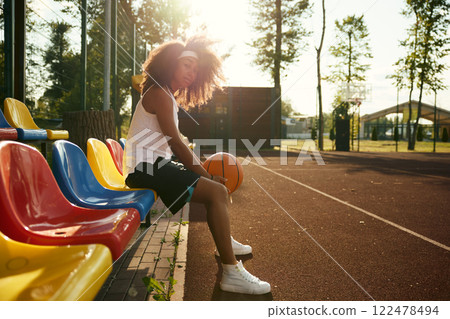 Attractive confident young sportswoman with basketball ball in hands 122478494