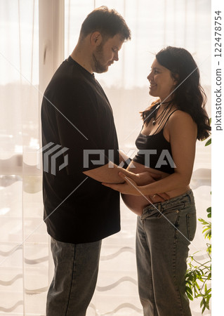 Intimate Moment of Expecting Parents by the Window Intimate Moment of Expecting Parents by the Window 122478754