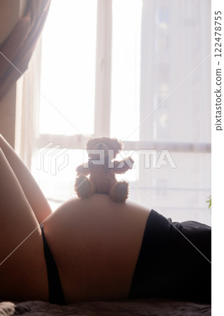 Pregnant Woman with toy Bear on Belly Pregnant Woman with toy Bear on Belly 122478755