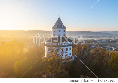 Humprecht chateau rises majestically above Sobotka amidst the tranquil autumn landscape, bathed in the warm glow of sunrise, showcasing its unique elliptical architecture. Humprecht chateau rises majestically above Sobotka amidst the tranquil autumn landscape, bathed in the warm glow of sunrise, showcasing its unique elliptical architecture. 122479390