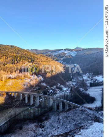 A stunning winter sunset illuminates a historic railway stone bridge in Novina, framed by the tranquil landscape and the distant Jested Mountain. A stunning winter sunset illuminates a historic railway stone bridge in Novina, framed by the tranquil landscape and the distant Jested Mountain. 122479395