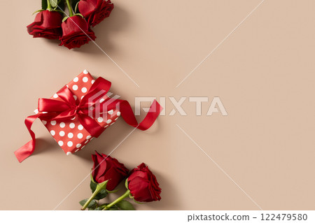 Valentine's day romantic gift and bouquet of red roses on beige background. Close up. Greeting card. Valentine's day romantic gift and bouquet of red roses on beige background. Close up. Greeting card. 122479580