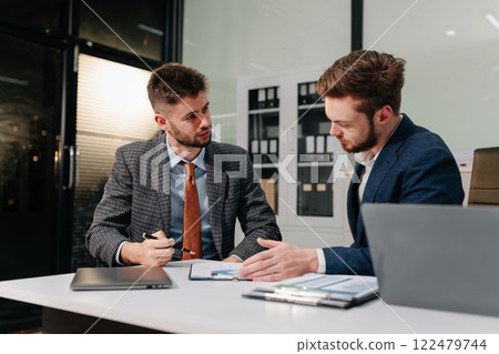 Diverse professionals using a tablet to analysis graph company financial in office. Diverse professionals using a tablet to analysis graph company financial in office. 122479744