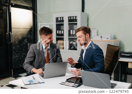 Diverse professionals using a tablet to analysis graph company financial in office. Diverse professionals using a tablet to analysis graph company financial in office. 122479745