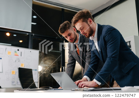 Diverse professionals collaborate on project analysis with financial graphs. Strategic teamwork and insights drive company growth and success. Diverse professionals collaborate on project analysis with financial graphs. Strategic teamwork and insights drive company growth and success. 122479747