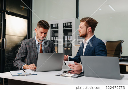 Diverse professionals collaborate on project analysis with financial graphs. Strategic teamwork and insights drive company growth and success. Diverse professionals collaborate on project analysis with financial graphs. Strategic teamwork and insights drive company growth and success. 122479753