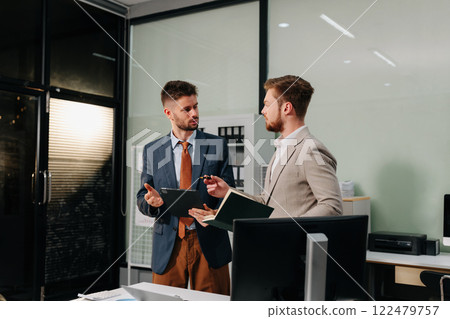 Diverse professionals collaborate on project analysis with financial graphs. Strategic teamwork and insights drive company growth and success. Diverse professionals collaborate on project analysis with financial graphs. Strategic teamwork and insights drive company growth and success. 122479757