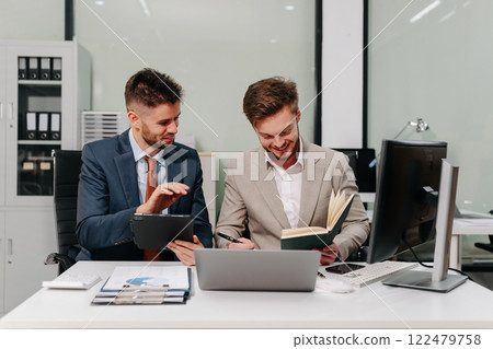 Diverse professionals collaborate on project analysis with financial graphs. Strategic teamwork and insights drive company growth and success. Diverse professionals collaborate on project analysis with financial graphs. Strategic teamwork and insights drive company growth and success. 122479758