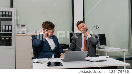 Businessman is doing a stretchy posture due to sitting in the office for too long. 122479786
