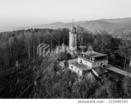 The lookout tower on Prosec Ridge near Jablonec nad Nisou overlooks the Jizera Mountains, showcasing stunning autumn colors during a serene sunset glow. Black and white photography The lookout tower on Prosec Ridge near Jablonec nad Nisou overlooks the Jizera Mountains, showcasing stunning autumn colors during a serene sunset glow. Black and white photography 122480293